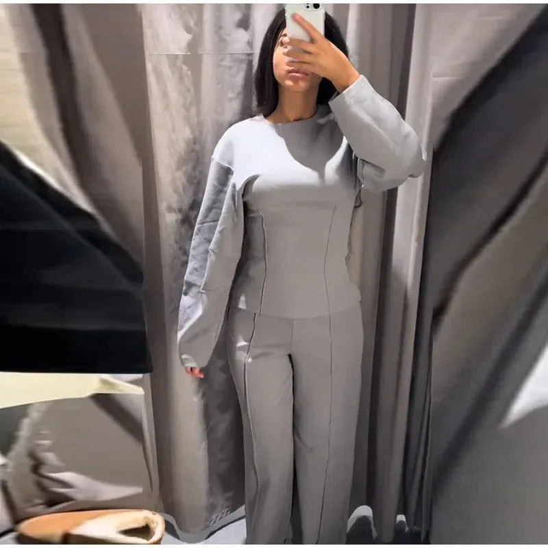 Women's black polar fleece suit set with long sleeve O-neck top and wide leg trousers.