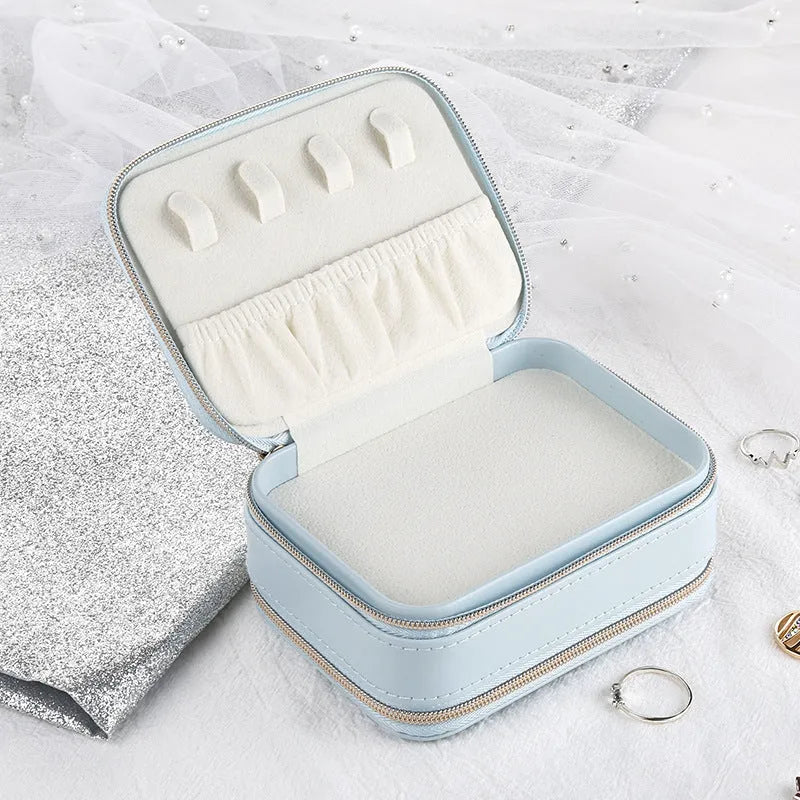 Light blue PU leather zipper jewellery box on a flat surface, compact 11.5x8.5x5cm size