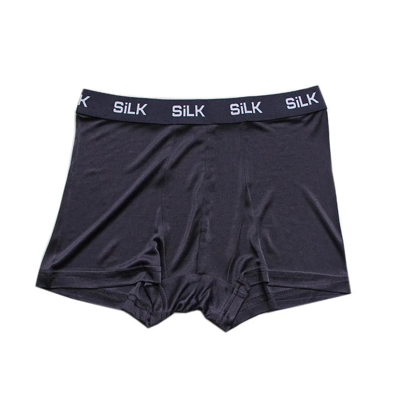 Man wearing loose-fit navy blue silk shorts with a mid waist design.