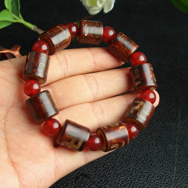 Distressed agate Tibet bead bracelet with three-eye motifs and multiple traditional bead styles on wrist