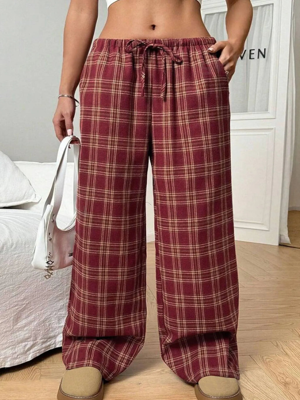 Women's red loose fit casual trousers with drawstring waist and plaid pockets, laid flat.