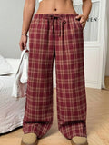 Women's red loose fit casual trousers with drawstring waist and plaid pockets, laid flat.