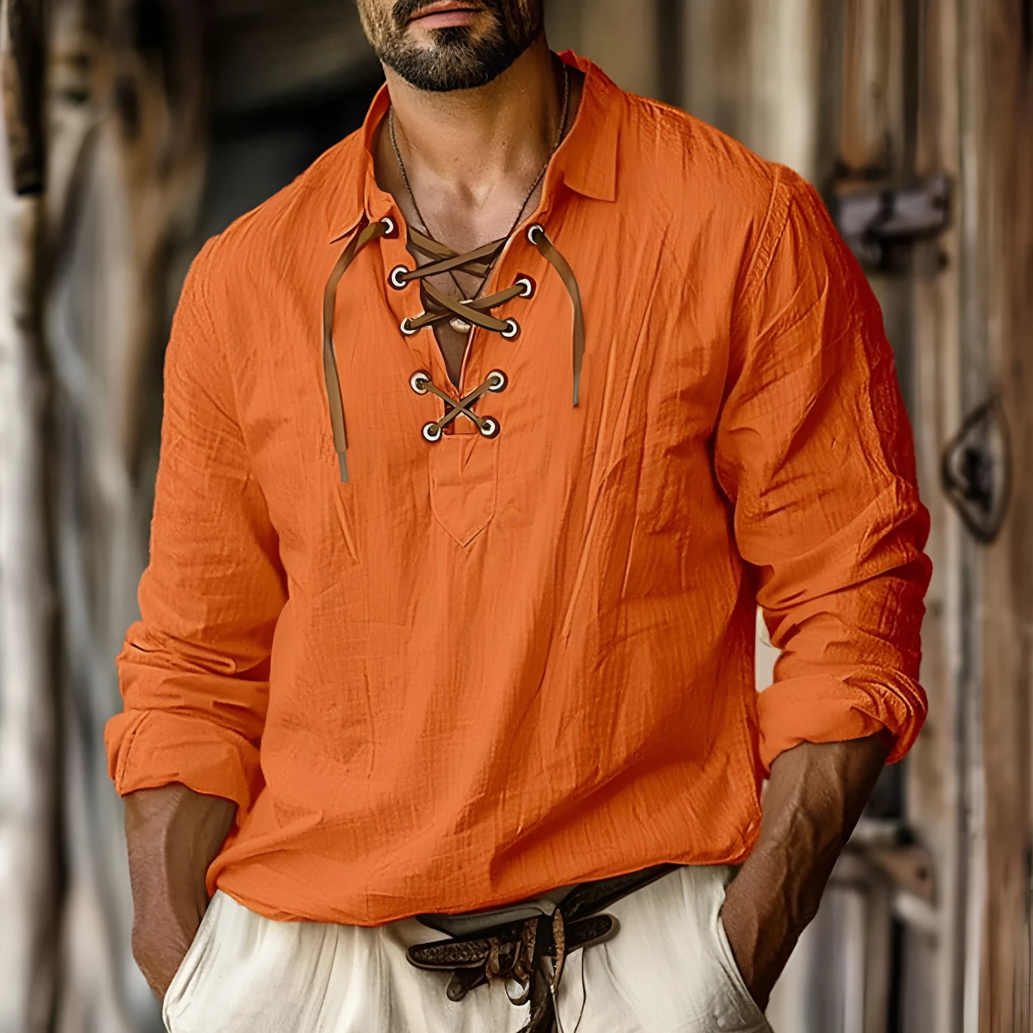 Man wearing a solid blue loose-fit linen blend shirt with lapels and lace detailing on the front.