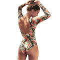 Women's backless one-piece swimsuit with green leaf print pattern on polyester fabric.