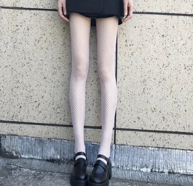 Women's black and white mesh pantyhose showing large, medium, and small fishnet patterns on leg