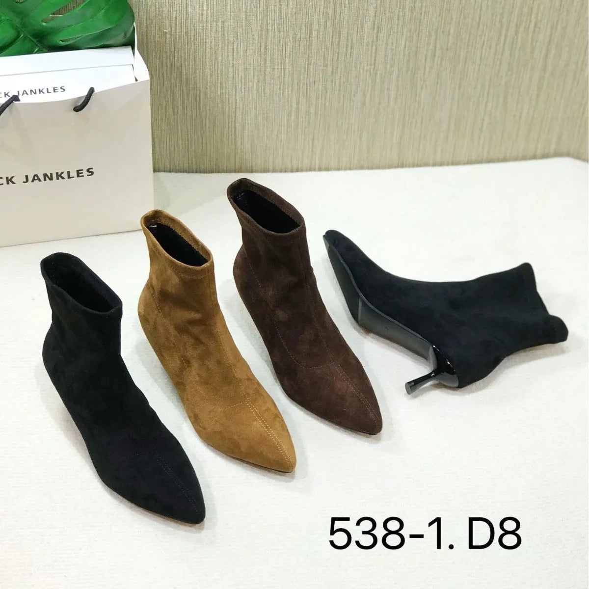 Black pointed toe women's ankle boots with a stiletto heel on a plain background.