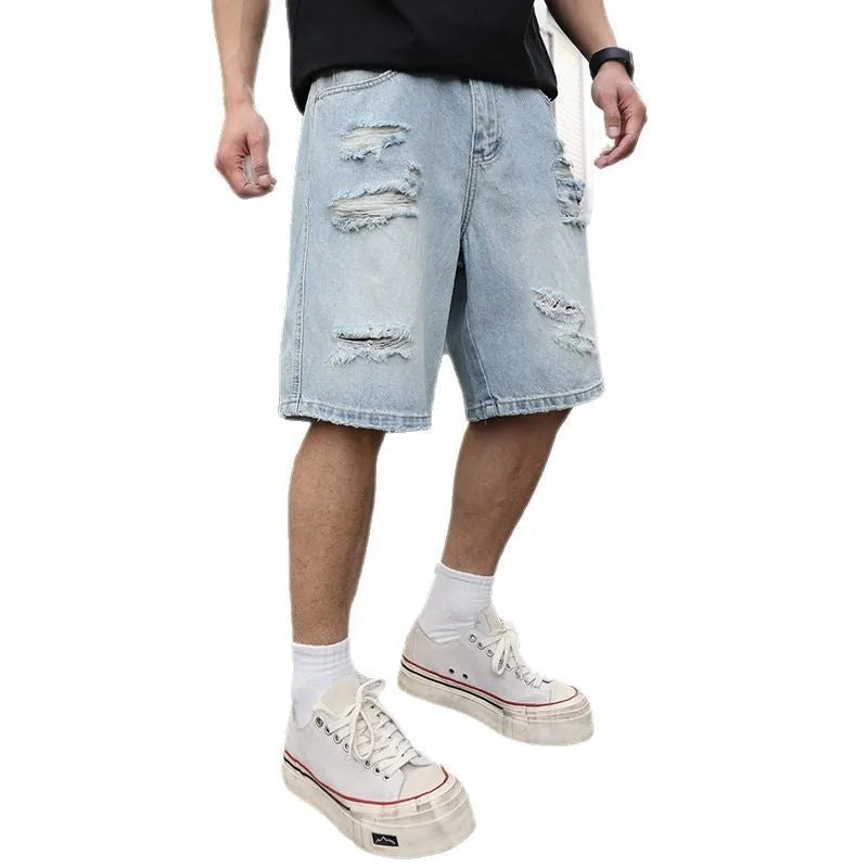 Light blue loose fit ripped denim shorts with distressed details on a straight leg.