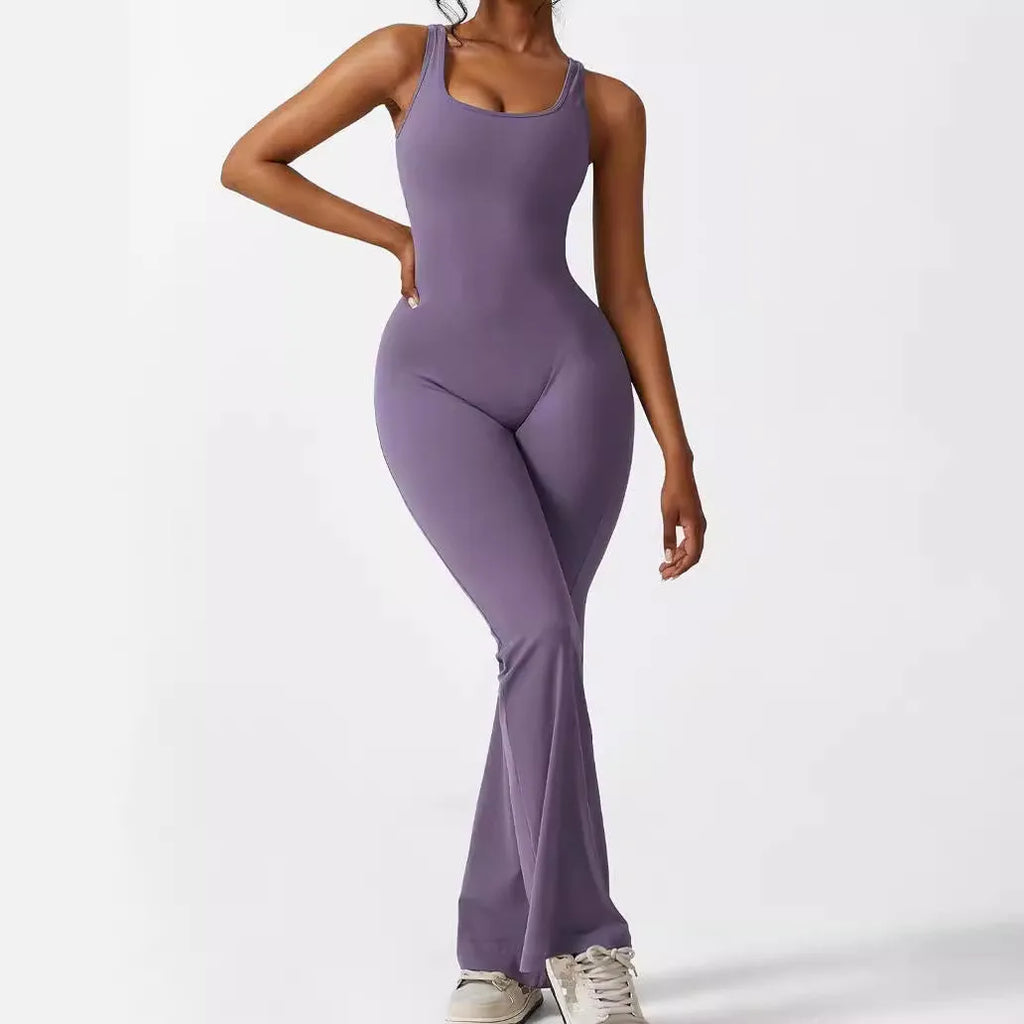 Woman wearing a sleeveless army green flare jumpsuit for yoga or fitness.