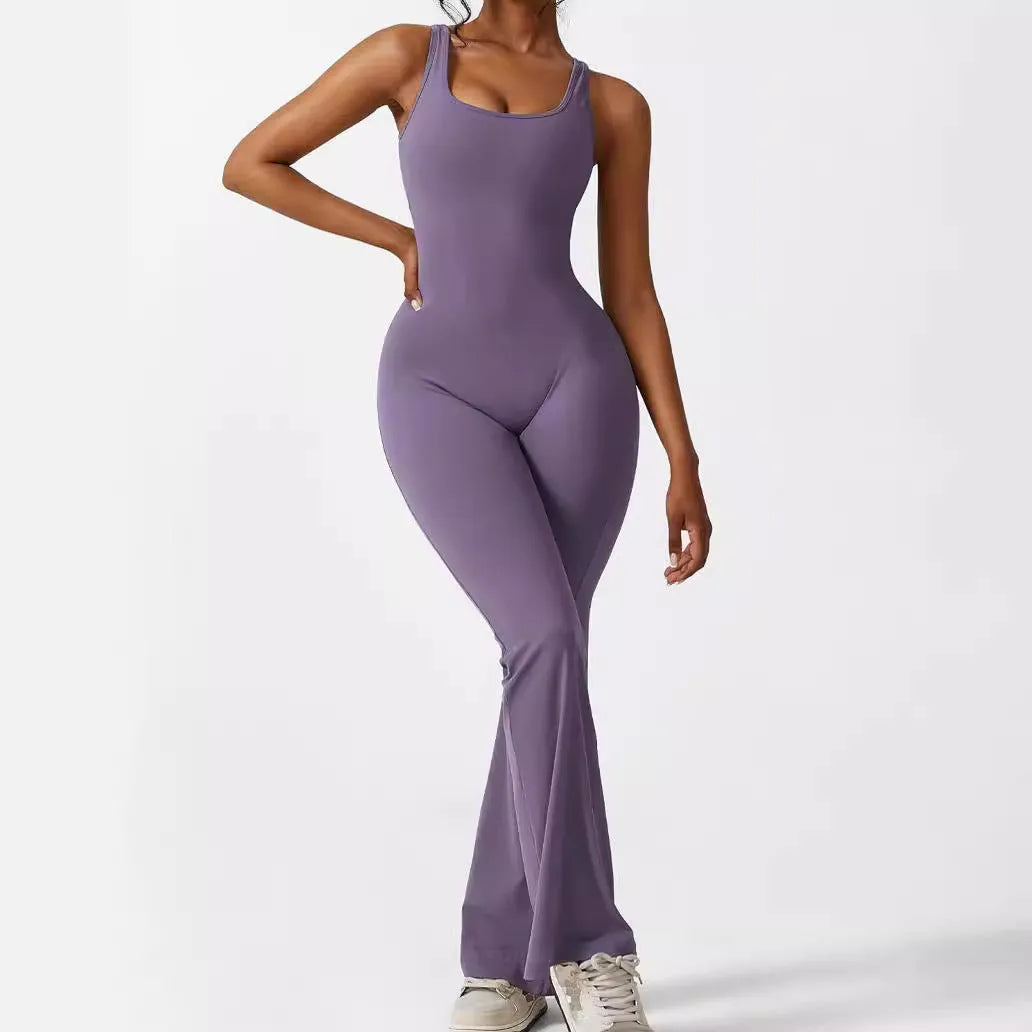 Woman wearing a sleeveless army green flare jumpsuit for yoga or fitness.