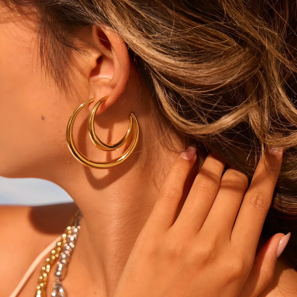 Titanium steel hoop earrings in gold and steel finishes, available in large and small sizes with simple geometric design