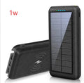Black solar power bank with wireless Qi charging pad, three USB ports, and an LED flashlight