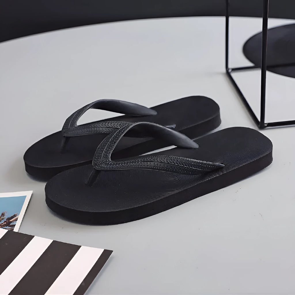 Casual rubber flip-flops with fish label on strap, showing non-slip sole.