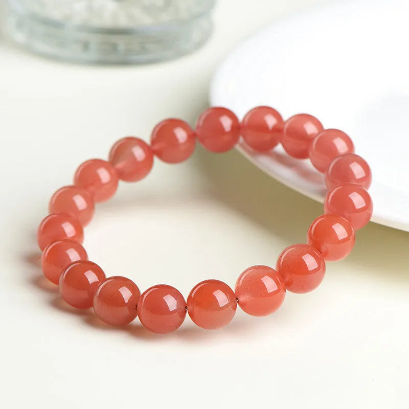 Natural cherry red agate scattered bead bracelet with polished stones on an adjustable strap.