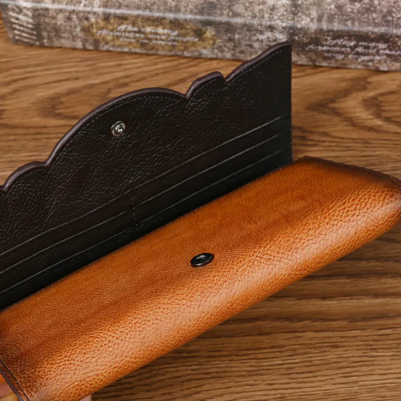 Women's brown genuine leather tri-fold wallet with embossed floral pattern showing interior compartments