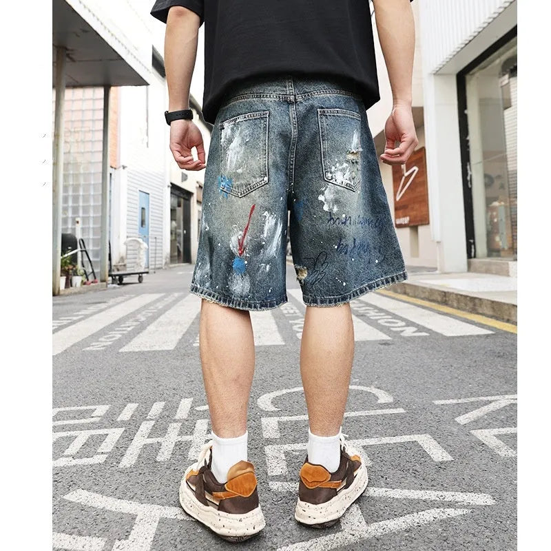 Blue men's ripped denim shorts with graffiti details and a straight leg opening.