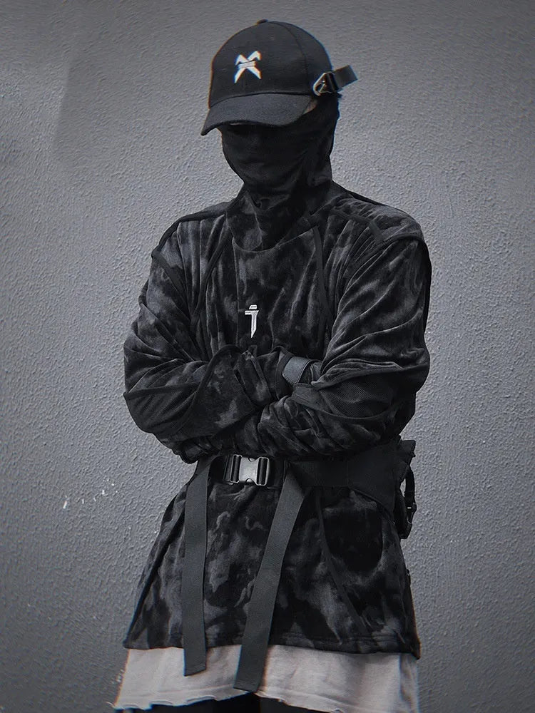 Man wearing a black and grey tie dye printed sweater with a finger turtleneck and drop shoulder sleeves.