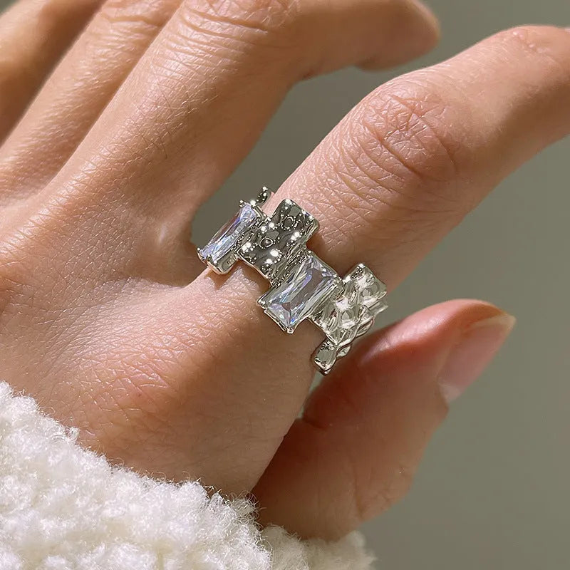 Geometric cross zircon ring with silver plating and open gemstone setting showing three-dimensional decoration
