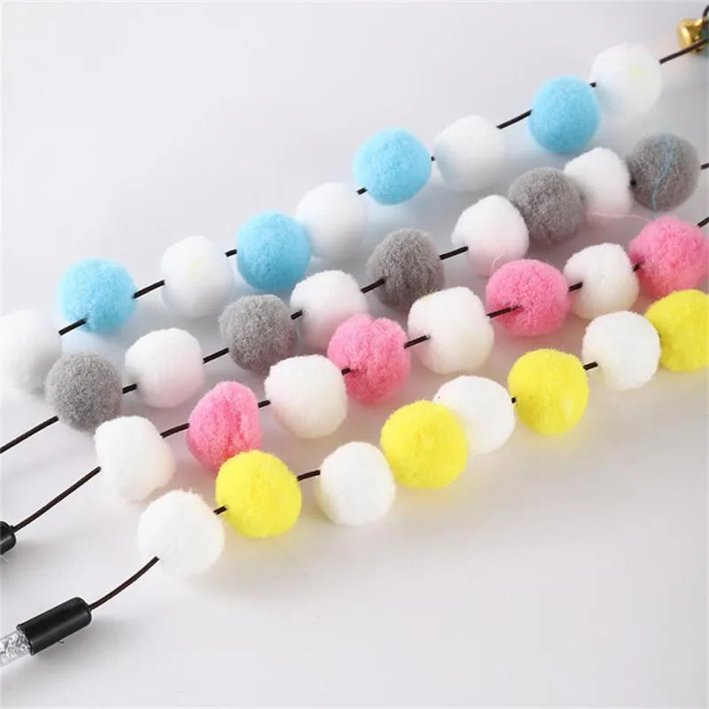 Colourful cat teaser toy rod with bell and pompon feather attachment on grey background