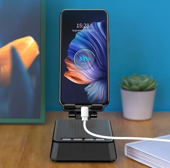 Black mobile phone broadcaster stand with Bluetooth speaker and microphone on desk