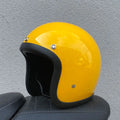 A retro-style motorcycle half helmet made from grey fibreglass, shown from the side.
