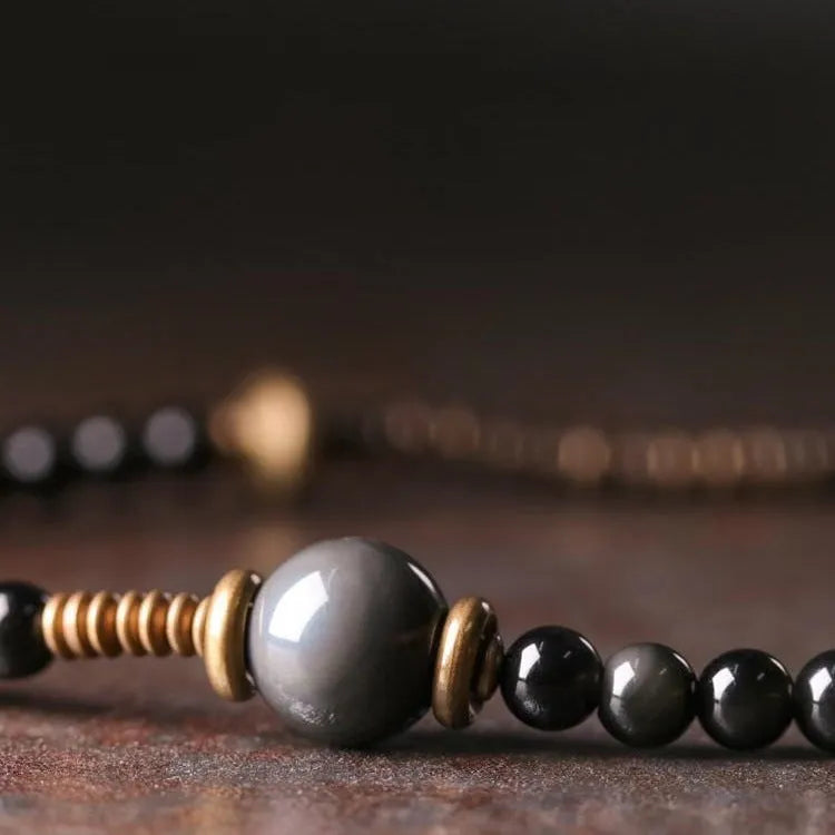 Close-up of a black multi-layered geometric bracelet made from beads, showing its textured construction.