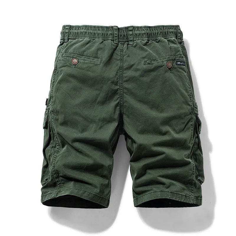 Men's army green cotton shorts with multiple zipper pockets and a Korean style design on a hanger.