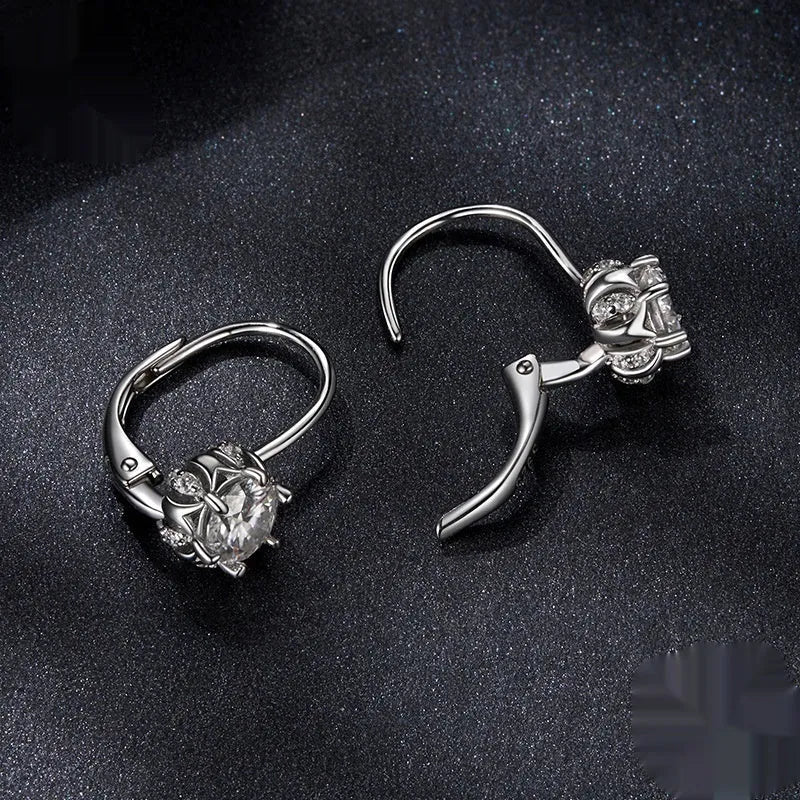 Sterling silver flower bud shaped ear clips with a white gold plated finish and a central moissanite stone.