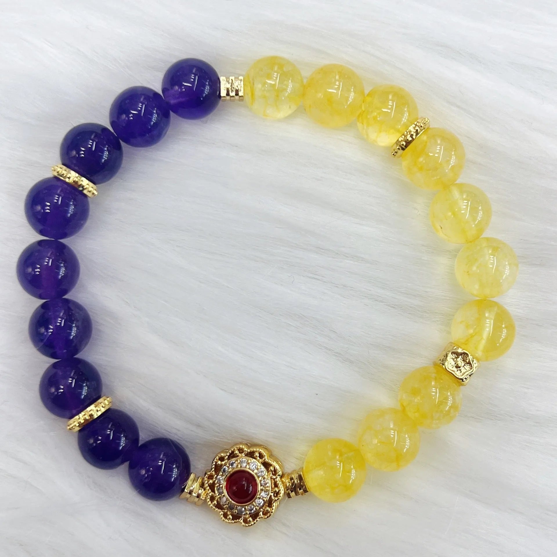 Handmade yellow and purple crystal bracelet for women on a wrist.