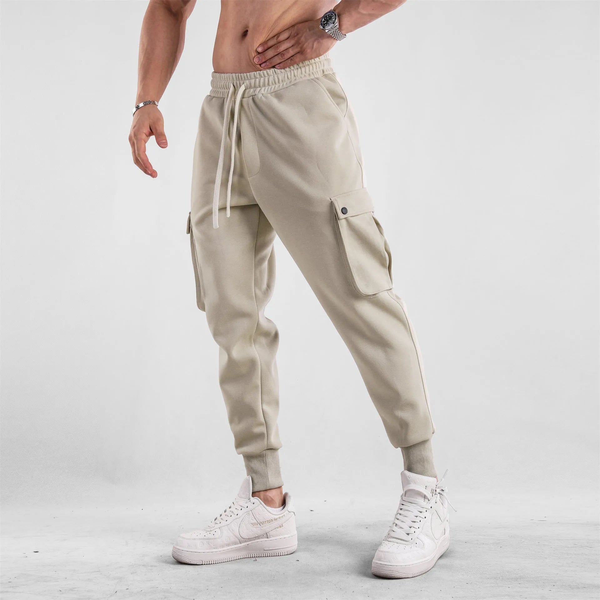 Men's loose cotton trousers with ankle ties in apricot colour showing multi-pocket design