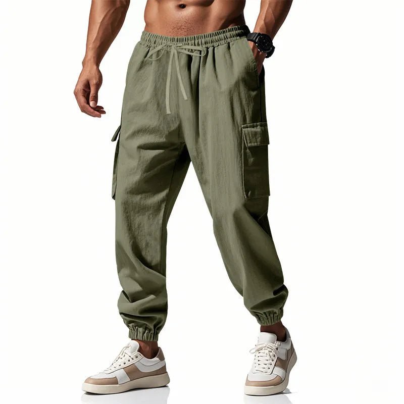 Men's solid colour linen casual trousers with ankle ties and drawstring waist on hanger.