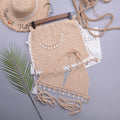 Women's black lace-up split bikini swimsuit on a beach background.