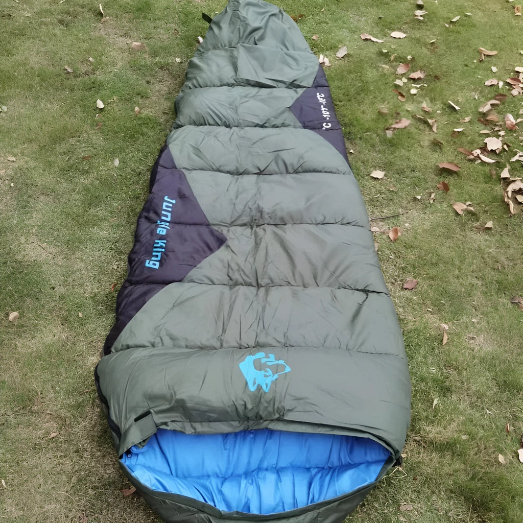 Cotton-filled camping sleeping bag in army green with its grey compression storage bag.