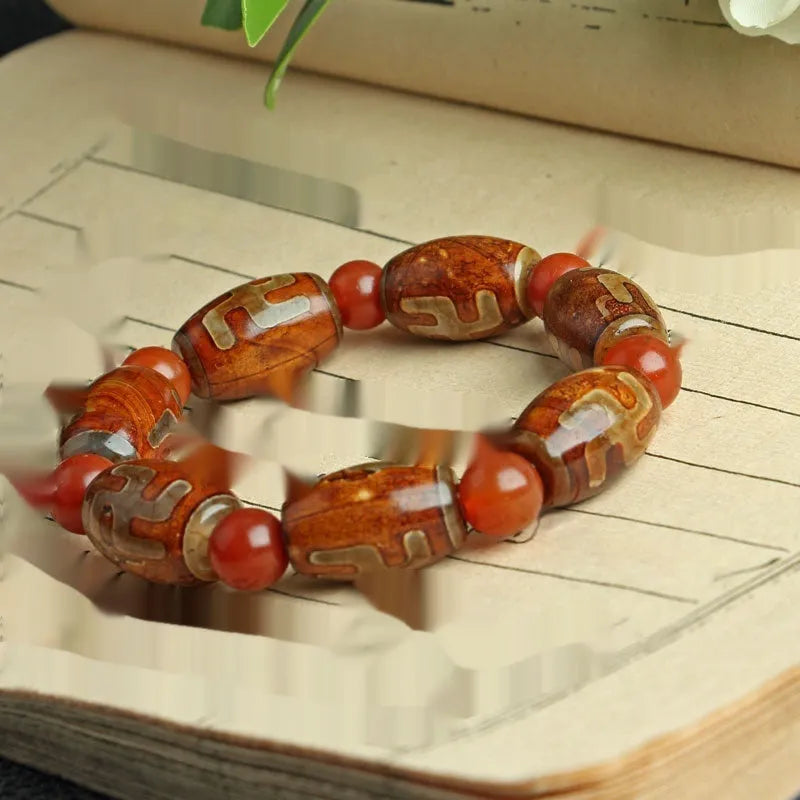 Distressed agate Tibet bead bracelet with three-eye motifs and multiple traditional bead styles on wrist