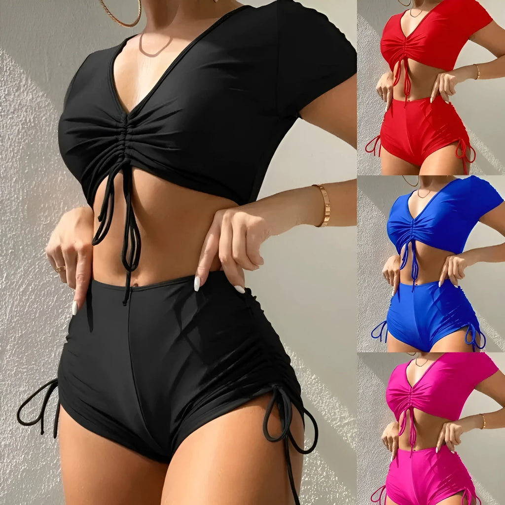 Lady's dark green lace-up front bikini top with matching swim shorts laid flat