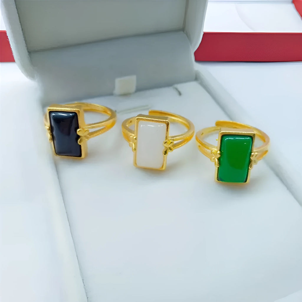 Adjustable gold-plated brass ring with a central gemstone inlay on a model's finger.