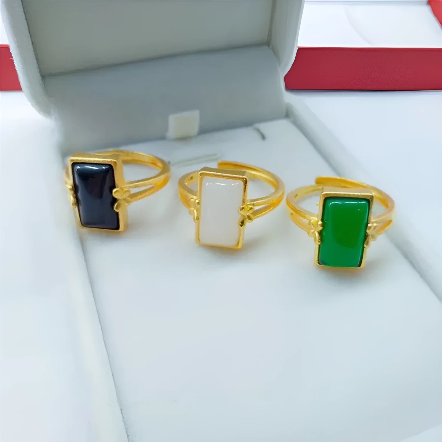Adjustable gold-plated brass ring with a central gemstone inlay on a model's finger.