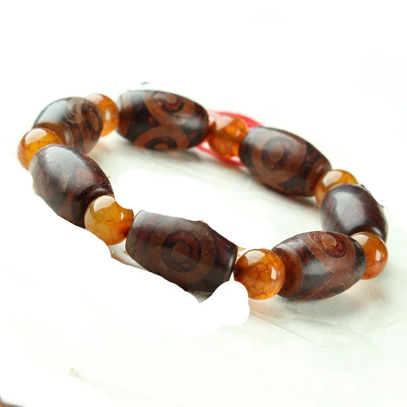 Distressed agate Tibet bead bracelet with three-eye motifs and multiple traditional bead styles on wrist