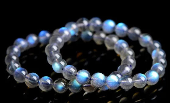 Natural blue moonlight cream body crystal bracelet on a wrist, showing polished beads.