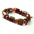 Distressed agate Tibet bead bracelet with three-eye motifs and multiple traditional bead styles on wrist