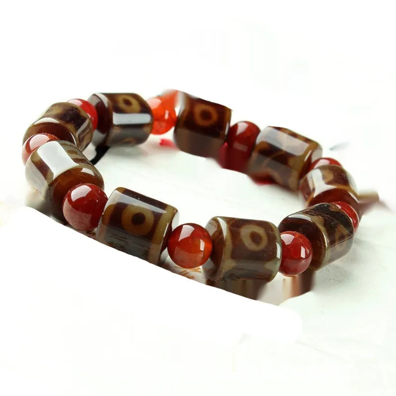 Distressed agate Tibet bead bracelet with three-eye motifs and multiple traditional bead styles on wrist