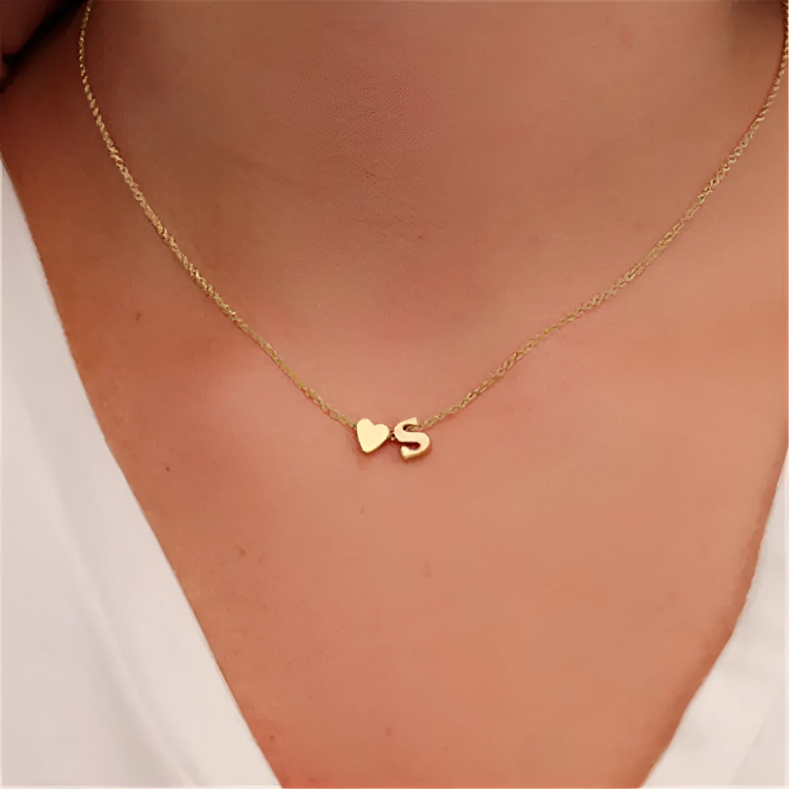Gold alloy peach heart-shaped pendant with a single letter charm on a silver chain.