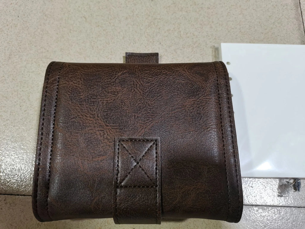 Brown A7 leather buckle notebook with loose-leaf binding on wooden surface