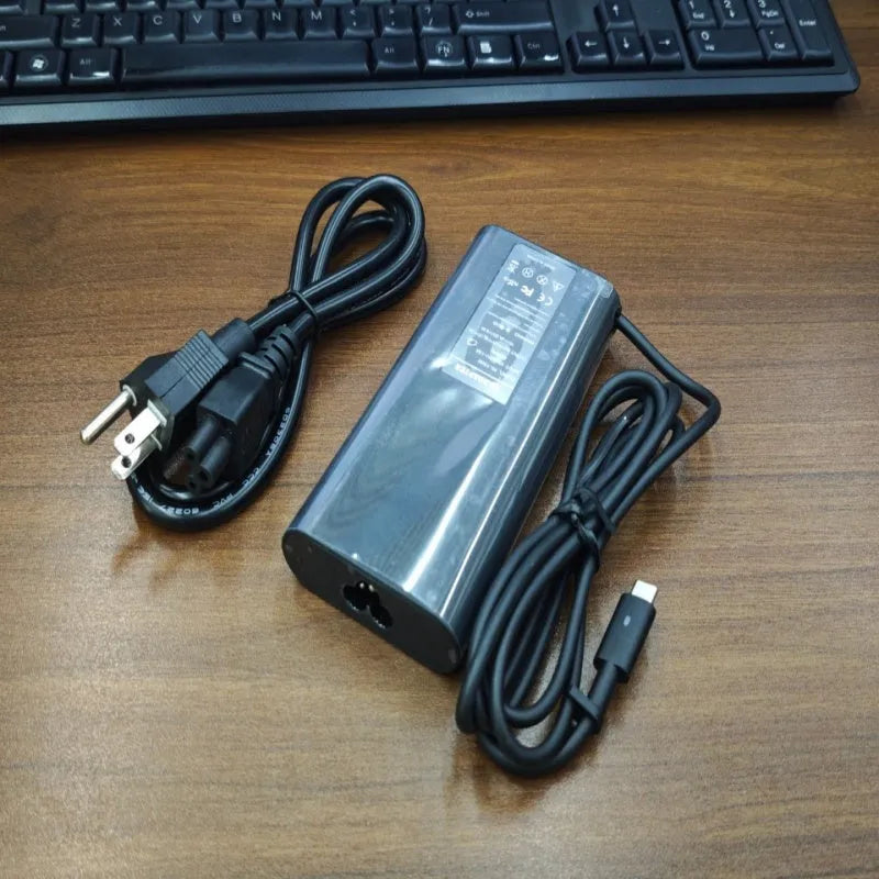 Black oval 65W Type-C laptop power adapter with international power cords