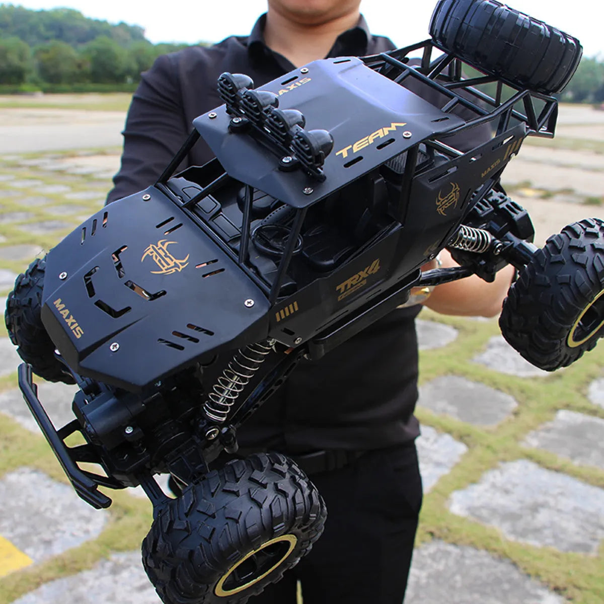 Large black 4WD remote control climbing car on rough terrain with wireless controller