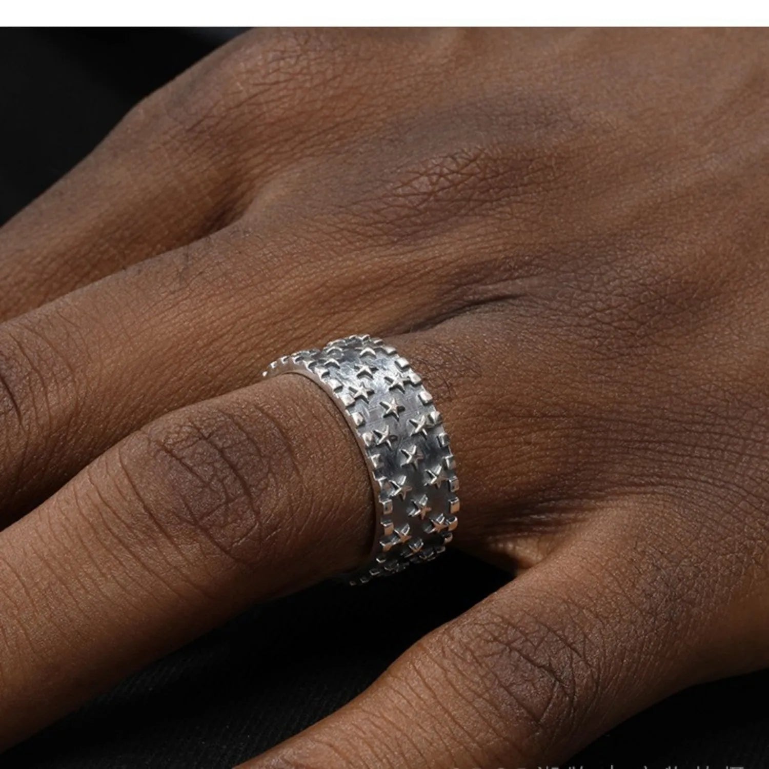 Adjustable open-ended sterling silver ring with a multi five-pointed star geometric pattern.