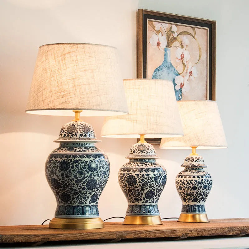 Chinese style blue and white porcelain table lamp with handmade ceramic base and cloth shade on bedside table