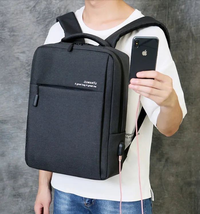 Black waterproof Oxford cloth laptop backpack with shoulder straps, shown with a laptop and charging cable.