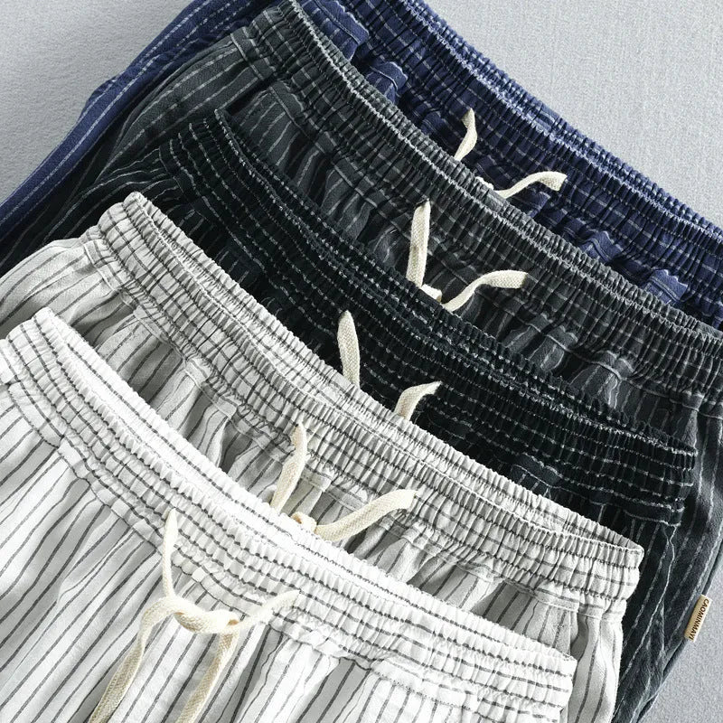 Man wearing striped casual cotton shorts with a loose straight fit and mid waist, showcasing the micro elastic fabric.