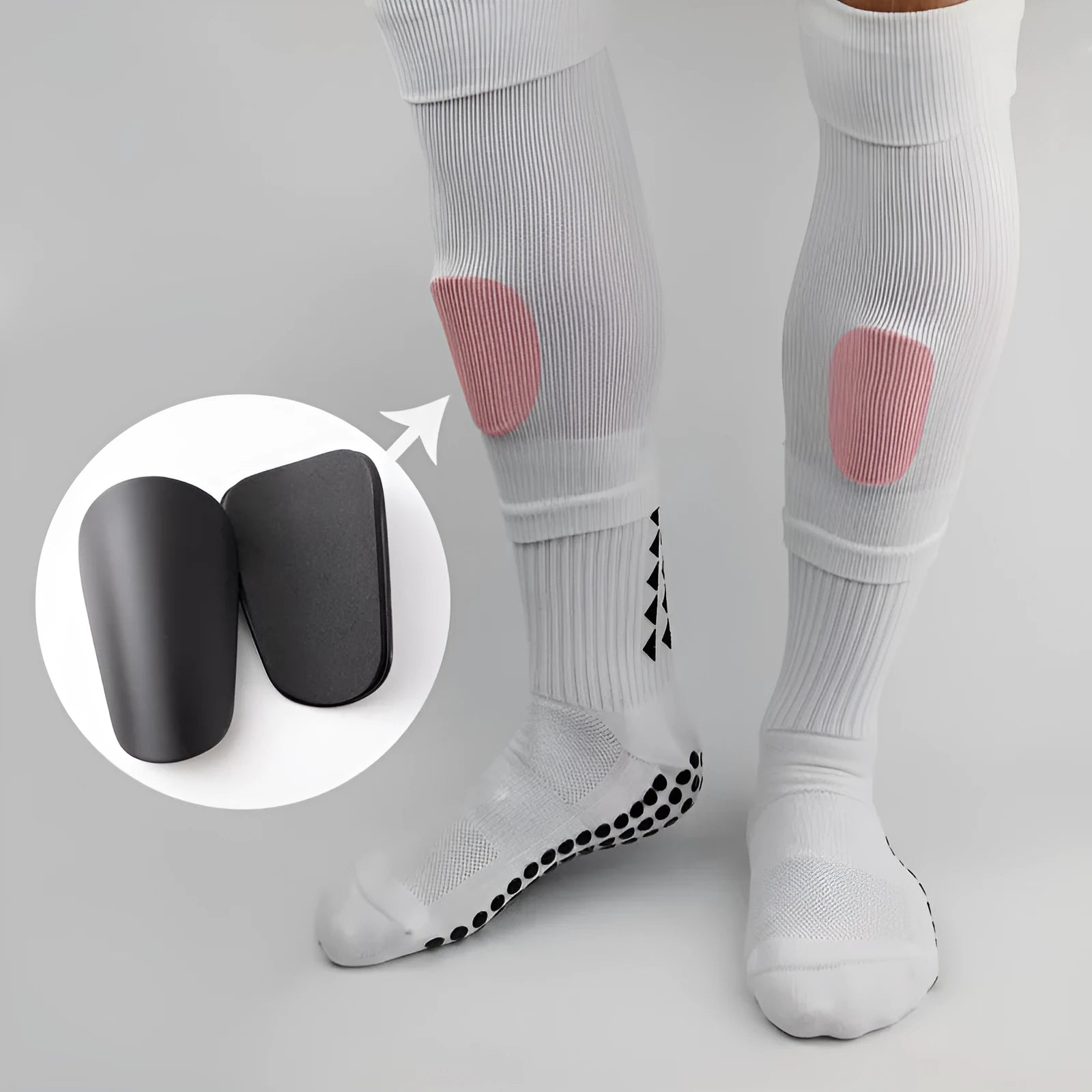 Pair of PU mini shin guards in black with adjustable straps, shown on a leg.