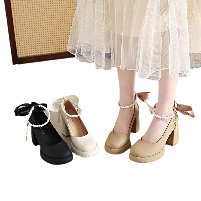 Women's beige Mary Jane shoes with chunky heel and ankle strap buckle on a wooden floor.